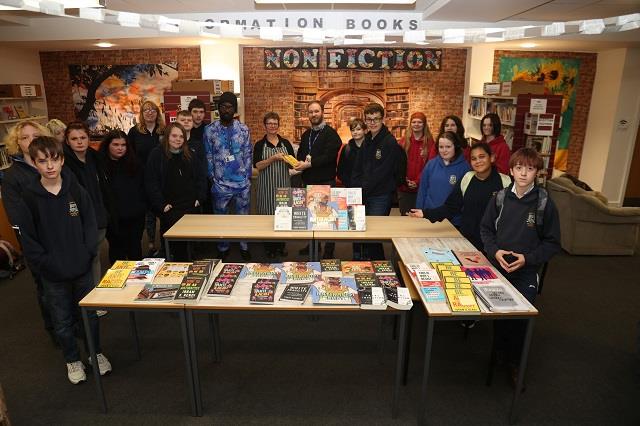 Photo of pupils from KGS Anti Racism Group presenting resources to their school library.